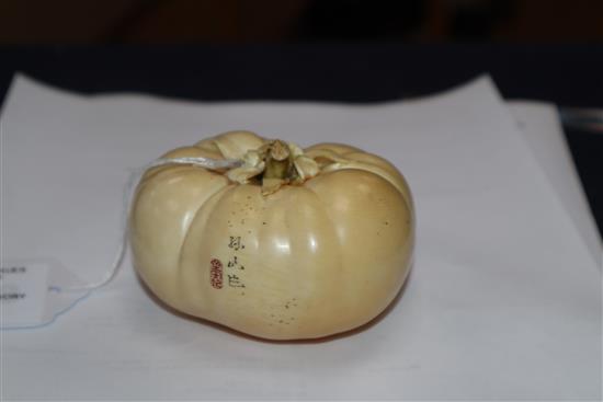 A good Japanese ivory model of a persimmon fruit, early 20th century, three character signature and seal, remnants of colouring to base